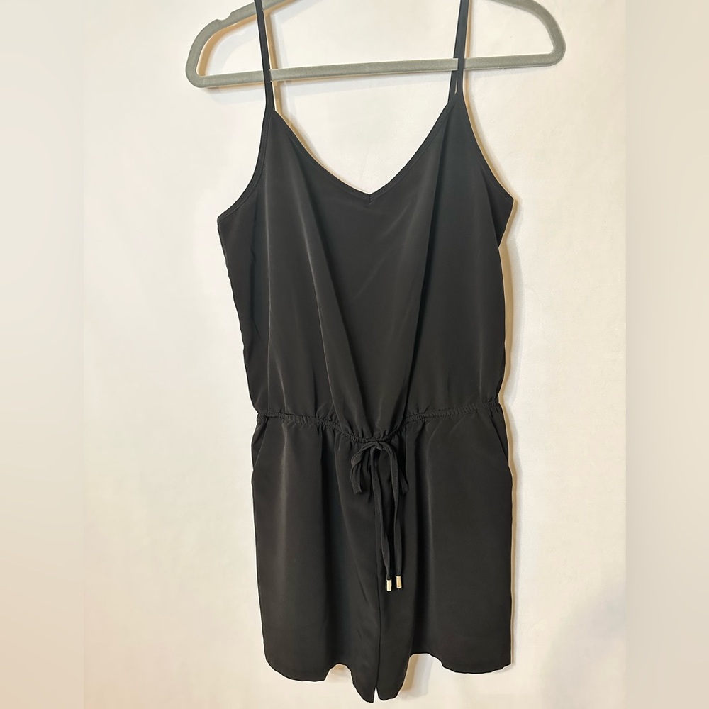 Black Romper with adjustable waist/straps and has pockets